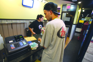 Josh Dann, one of the owners of Zonies, collects money after an order late Monday night. Delivery mixups have taken place since the opening of the new location.