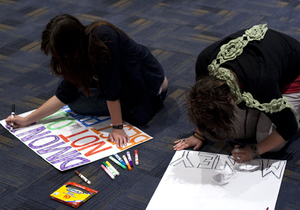 Emily Gagliardi, a senior international relations major, makes a sign for Fridays protest against JPMorgan Chase CEO Jamie Dimon as commencement speaker.