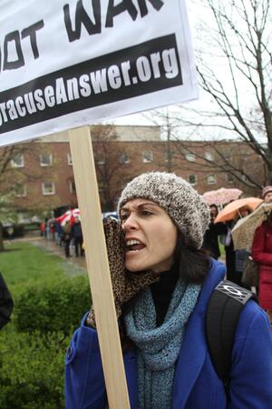 Risa CDeBaca, a senior womens and gender studies major, protests Hillary Clintons visit outside of Hendricks Chapel. CDeBaca took part in a protest staged by the Syracuse Answer Coalition.