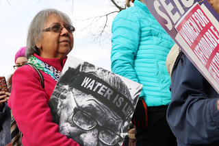 A woman holds a sign that says 